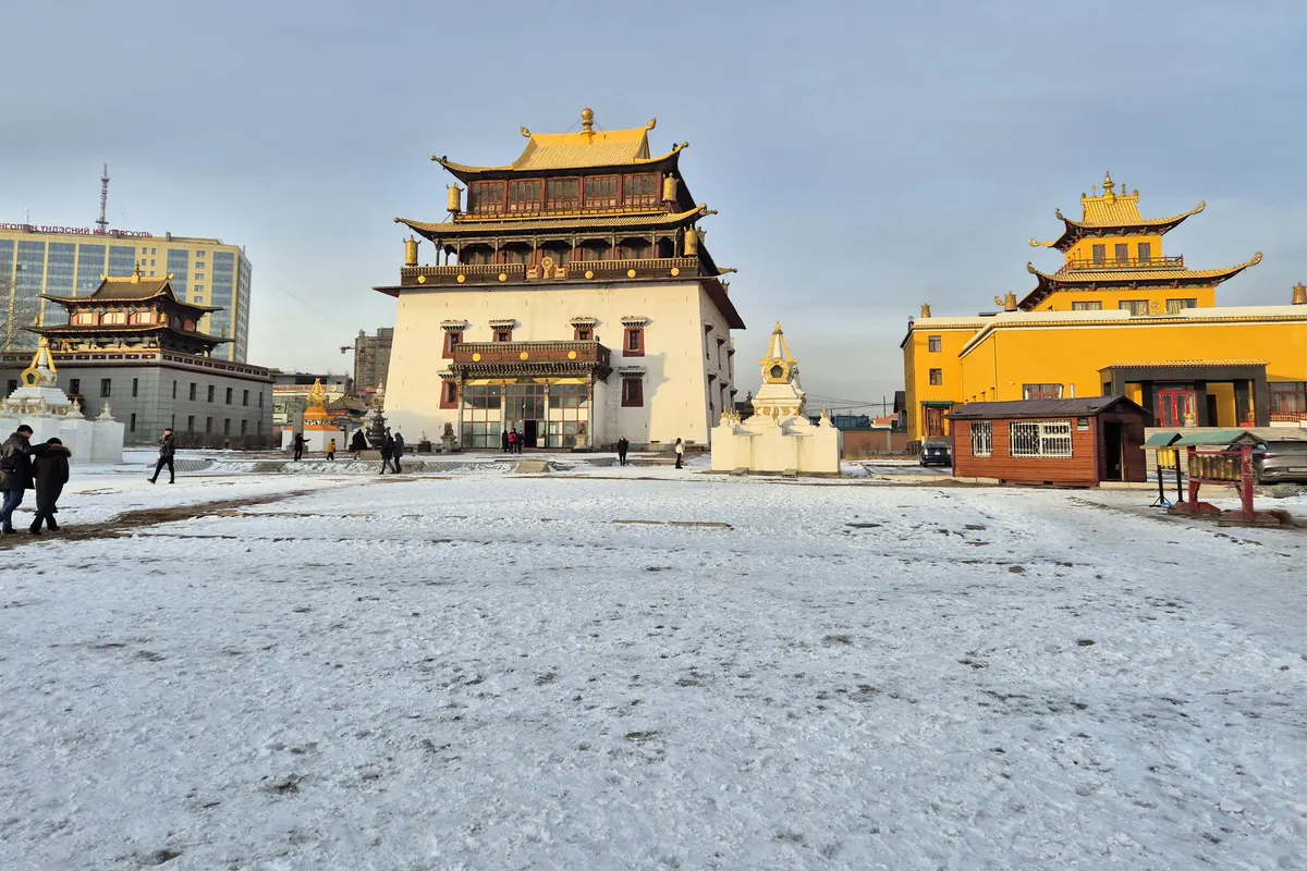 Golden-roofed temples and white stupas at Gandantegchinlen Monastery in Ulaanbaatar, with snow on the ground
